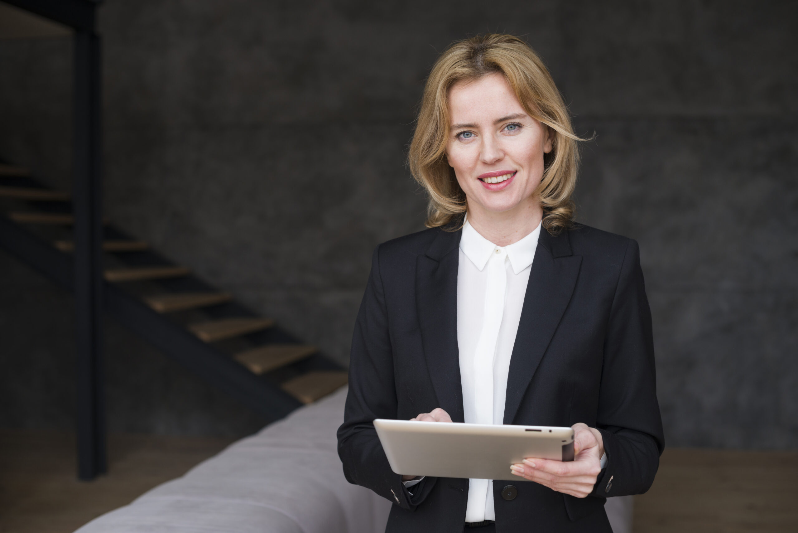 blond-business-woman-suit-using-tablet
